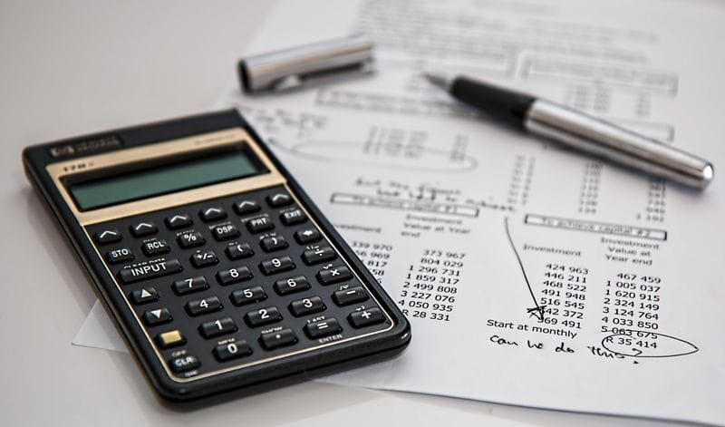 Calculator and payroll figures on a printed summary sheet
